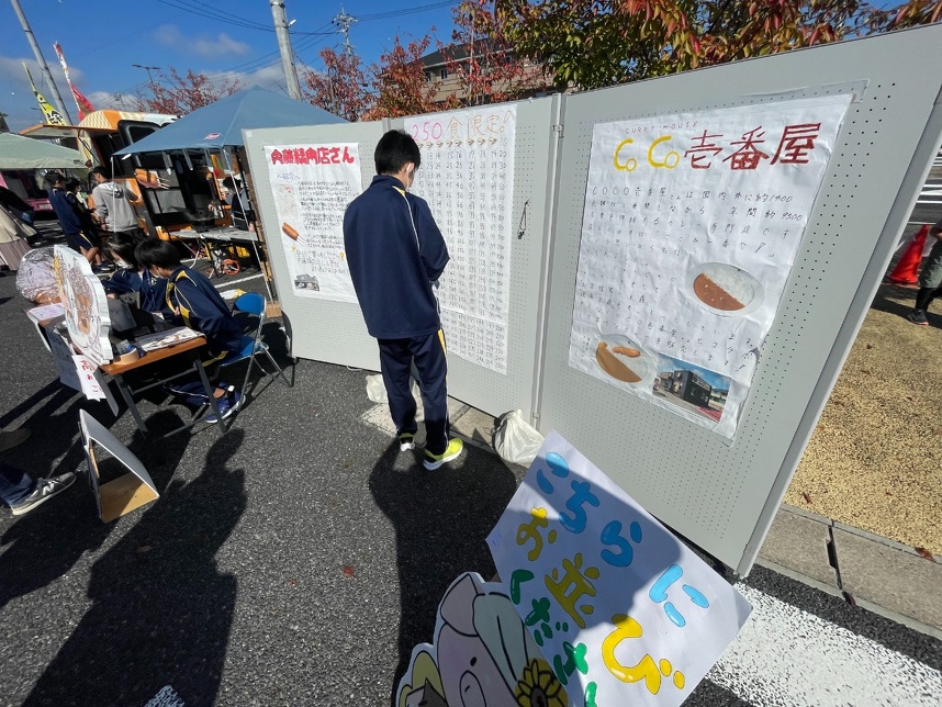 ２年４組のお店の案内板。１食売れるごとに、イラストが貼られていきます。当店の紹介文も。