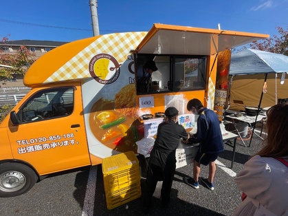 キッチンカー前に商品の串カツカレーを並べる生徒さん